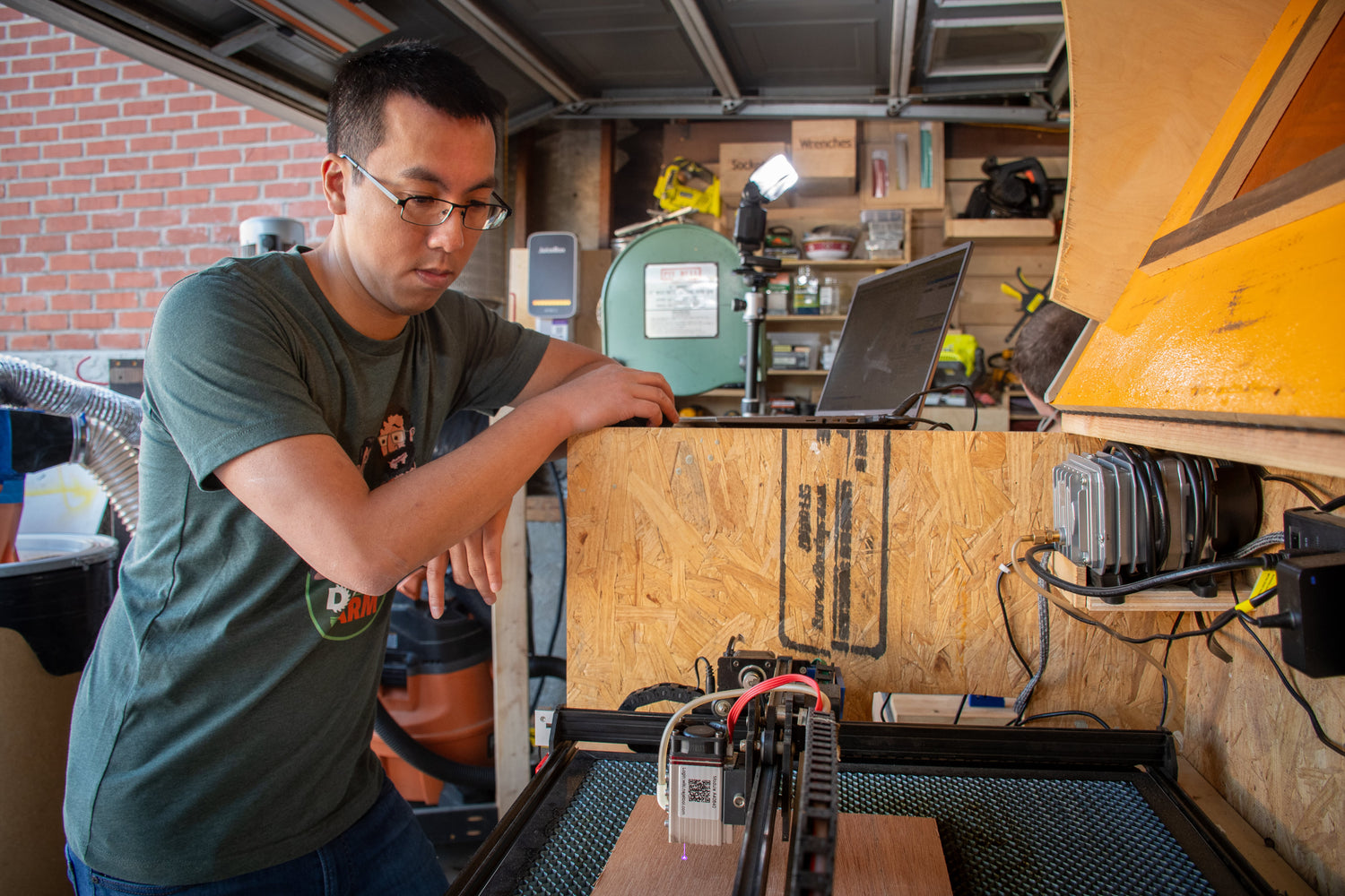 Andy aligning a wood piece for laser cutting.