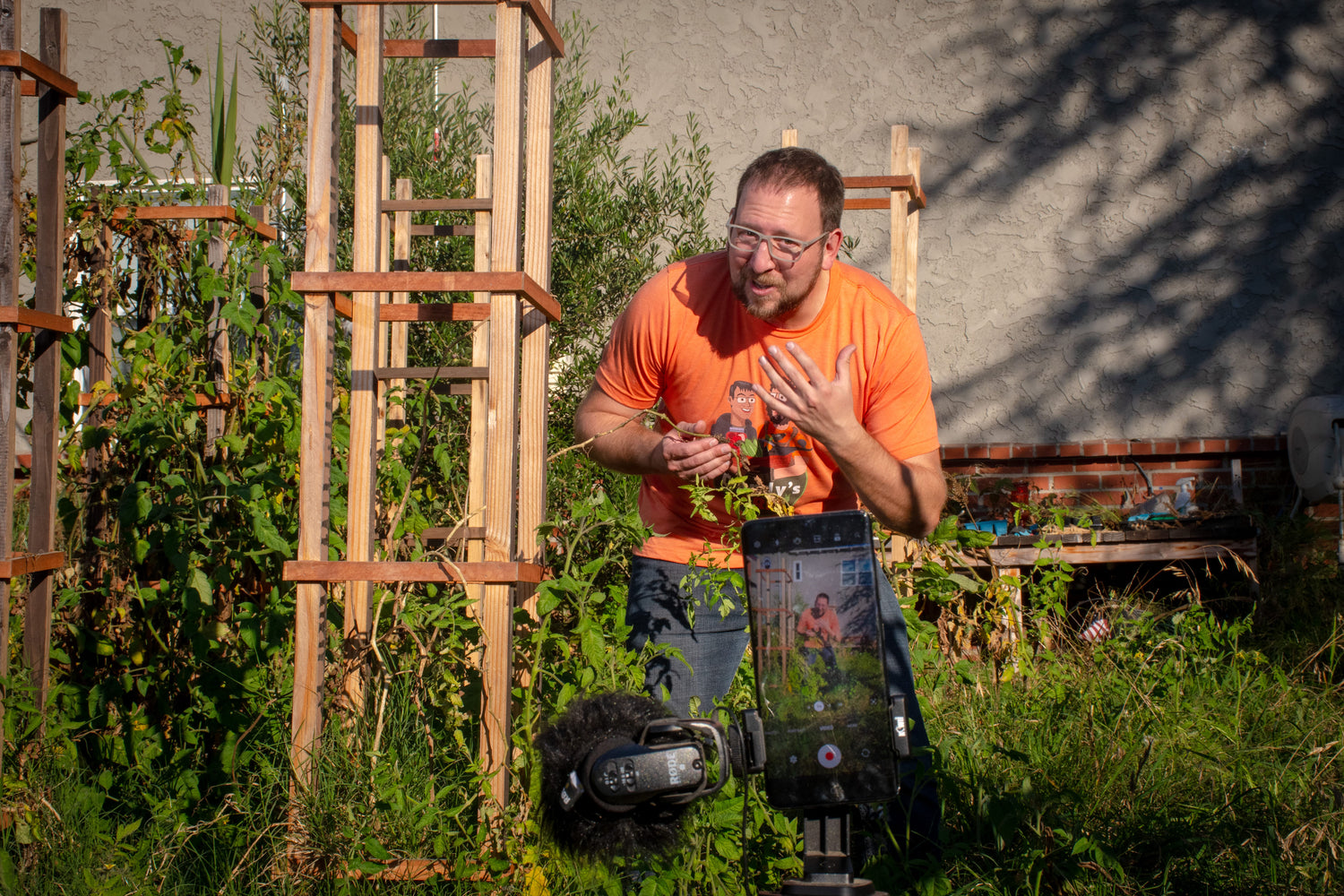 Behind the scene shot of Dan recording a video in the garden.